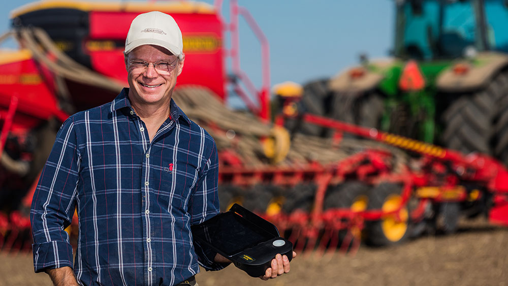 Farmer Peter Malmström from Sweden is smiling, holding a Väderstad E-control.